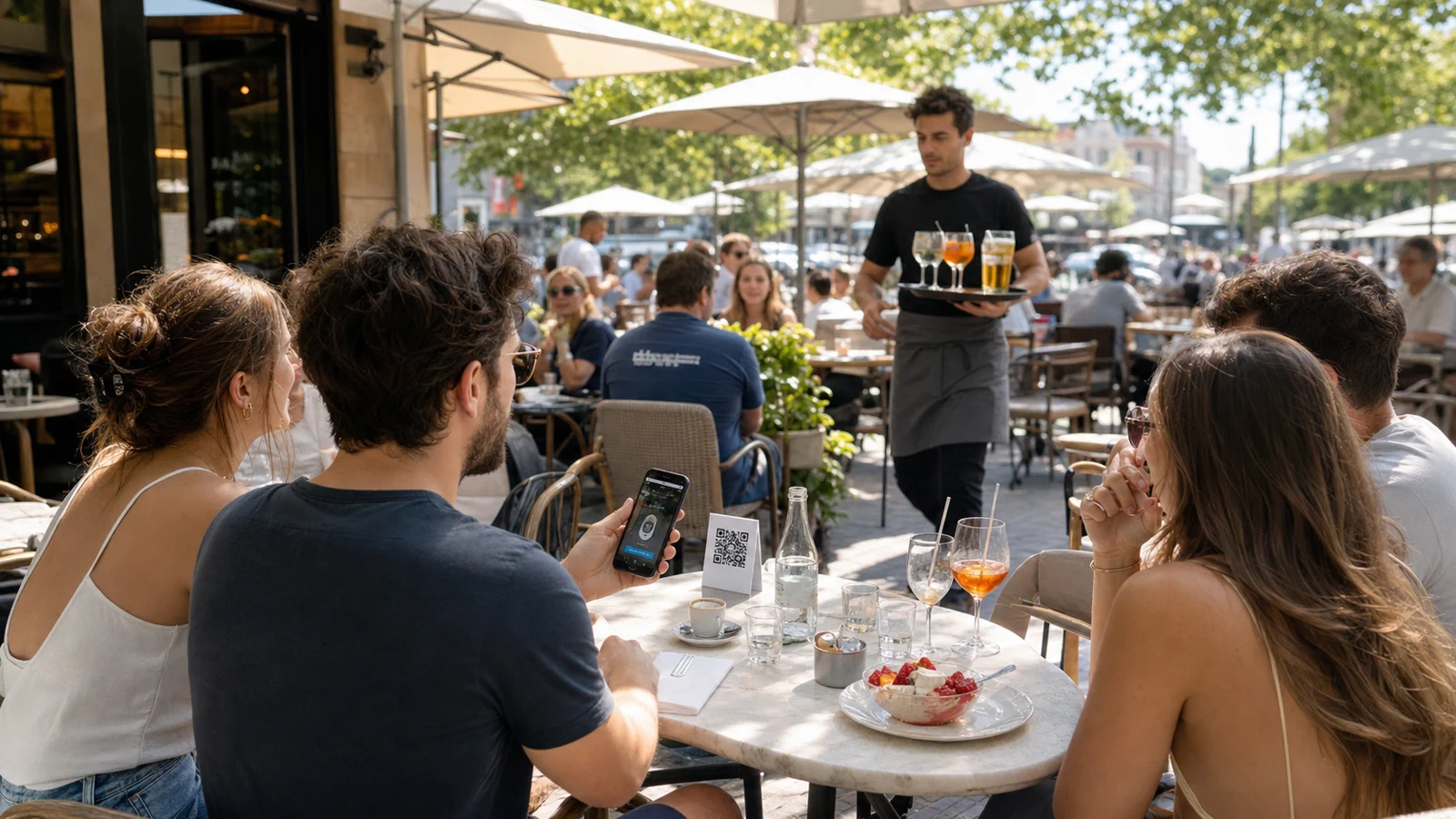 Terrasse de restaurant animée avec chevalet QR code, boissons et serveur en mouvement